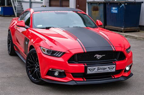 Royalty-Free photo: Red and black Ford Mustang coupe on concrete road ...