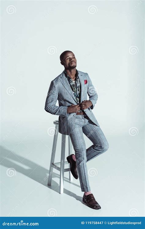 Stylish African American Man in Suit, Sitting on a Bar Stool and Holding Sides of Stock Image ...