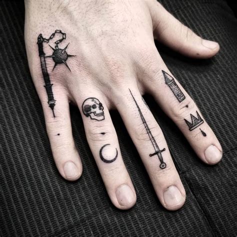 a person's hand with tattoos on it, including an arrow and a cross