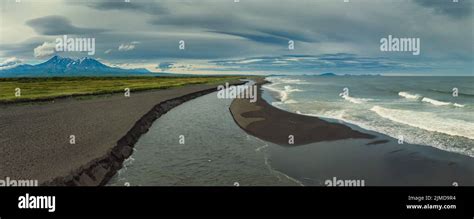 Beach with black sand and volcano Stock Photo - Alamy