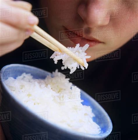 A Person Eating Rice with Chopsticks - Stock Photo - Dissolve