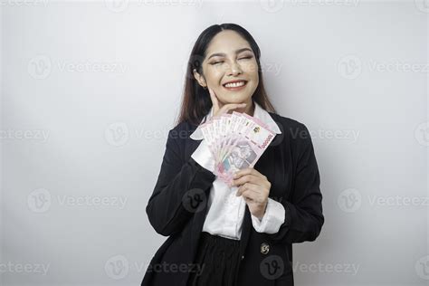 A thoughtful young woman is wearing black suit and holding cash money ...