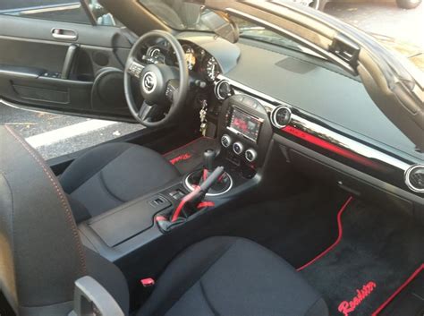 the interior of a sports car with red stitching