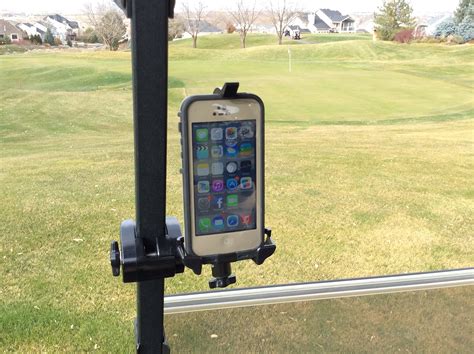 an iphone on a tripod in front of a window overlooking a green golf course