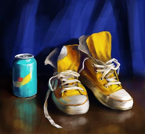 a pair of yellow shoes next to a can of soda on a wooden table with ...