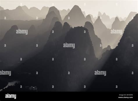 Sun rays coming through Karst peaks in China Stock Photo - Alamy