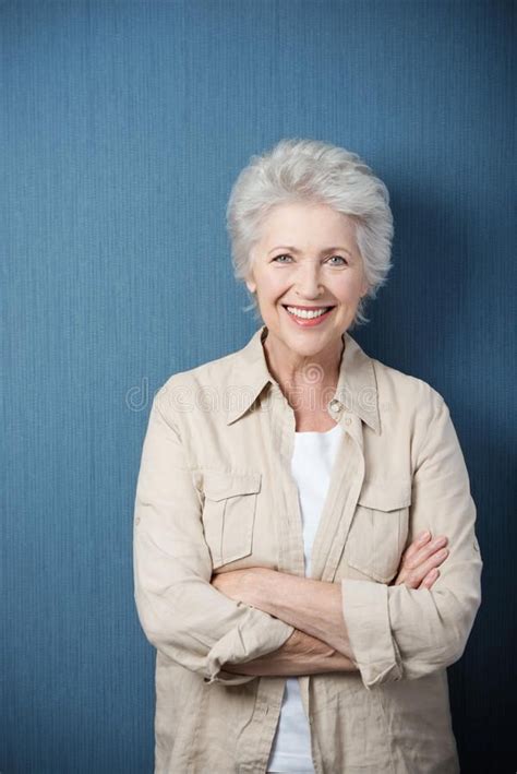 Stylish modern elderly woman. Standing smiling at the camera with ...