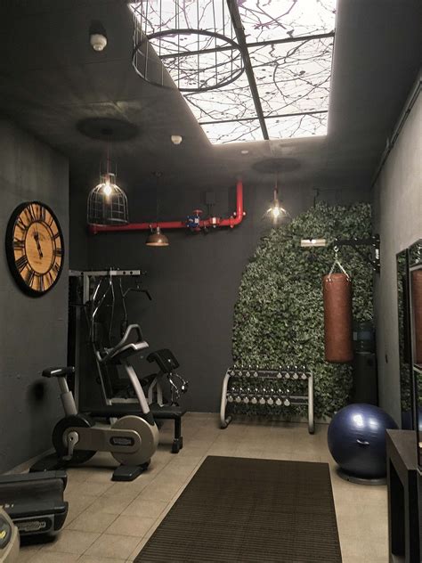 a home gym with exercise equipment and an indoor wall - mounted clock ...