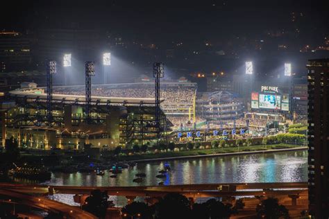 PNC Park is lit up at night during a Pittsburgh Pirates game - Metal Print