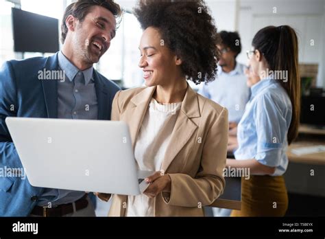 Happy business people celebrating success at company Stock Photo - Alamy