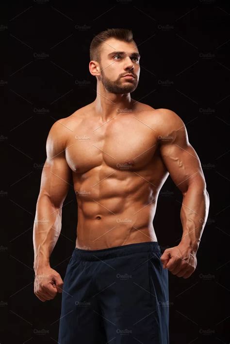 Fitness muscular man is posing and showing his torso with six pack abs ...