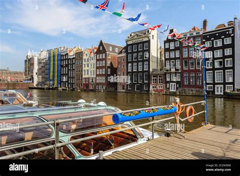 Dancing Canal Houses of Damrak, Amsterdam, Netherlands Stock Photo - Alamy