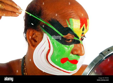 South Indian kathakali dancer applying makeup ; Kerala ; India MR#761C ...