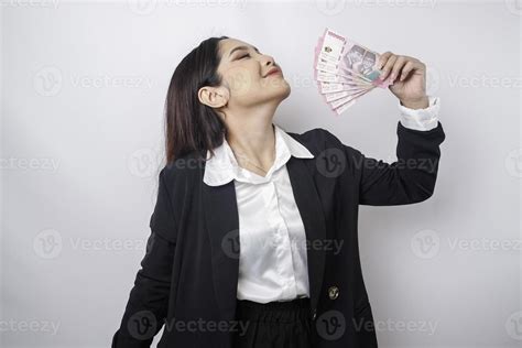 A happy young businesswoman is wearing black suit and holding cash ...