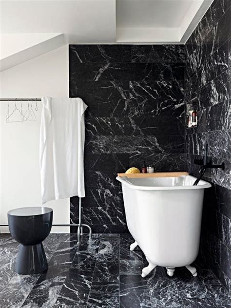 a white bath tub sitting next to a black wall