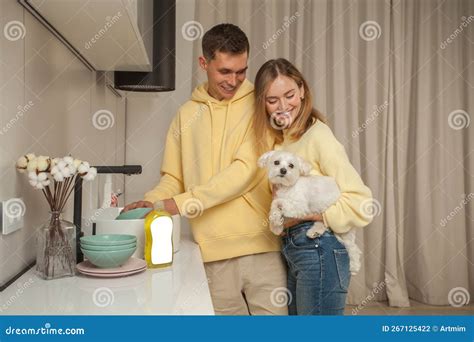 Portrait of Happy Couple in Yellow Hoodies, Man Washing the Dishes ...