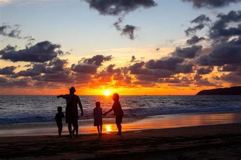 Premium Photo | Family playing on the beach at beautiful sunset with sunset