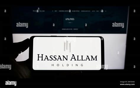 Person holding cellphone with logo of Egyptian conglomerate Hassan ...