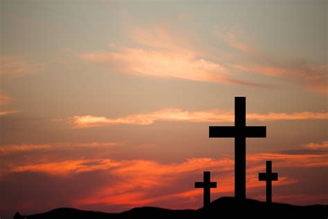 Three wooden crosses in silhouette stand silently on a hill at | Jesus ...