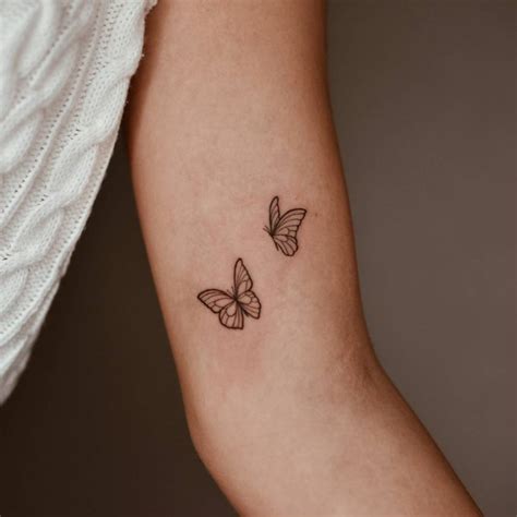 Fine line butterfly couple tattoo on the inner arm.