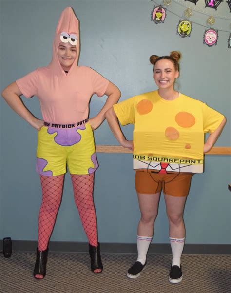 two people in costume standing next to each other with their hands on ...