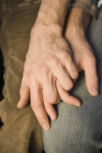 Close-up of two men holding hands stock photo - OFFSET