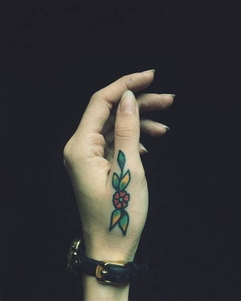 Traditional flower tattoo on a thumb - Tattoogrid.net