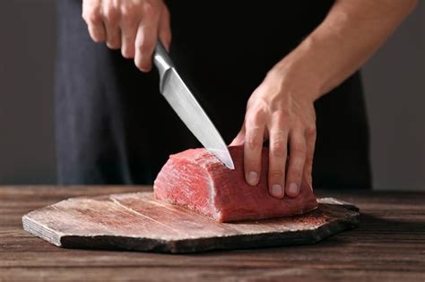 Premium Photo | Butcher cutting pork meat on kitchen