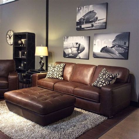 Family room with warm gray walls, black and white art, brown leather ...