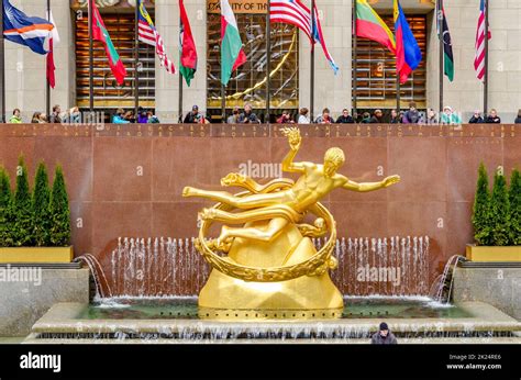 Golden Prometheus statue at Rockefeller Center during winter with flags ...