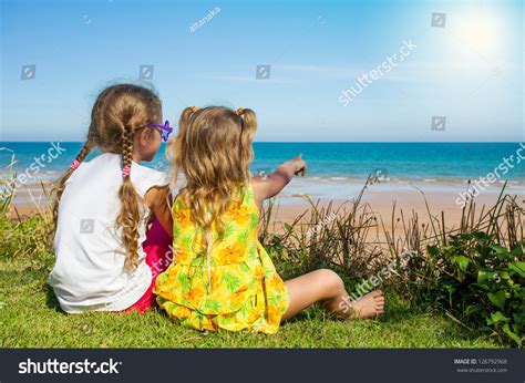 Two Girls Sitting On The Beach And Watching The Sea Stock Photo ...