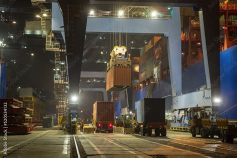 operation of container terminal at night. Unloading container ship at ...