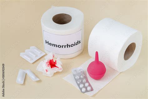 Hemorrhoids treatment concept. Toilet paper with blood next to enema ...