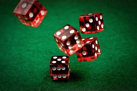 four red dices sitting on top of a green table