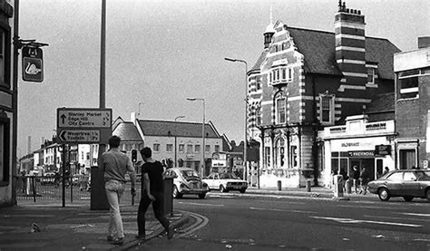 black and white photograph of people walking down the street