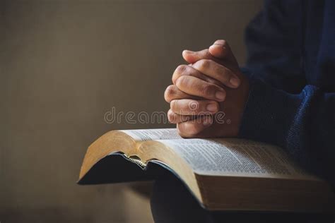 Hands Folded in Prayer on a Holy Bible in Church Concept for Faith ...