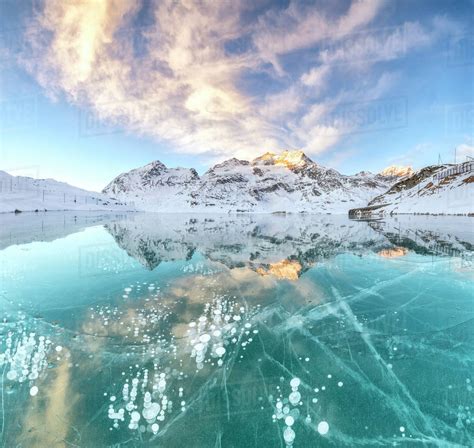 Panorama of ice bubbles and frozen surface of Lago Bianco at dawn ...