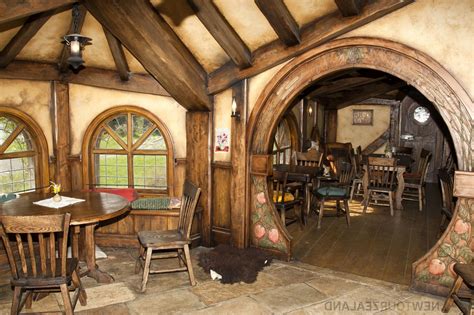 the inside of a hobbot house with wooden tables and chairs, windows ...