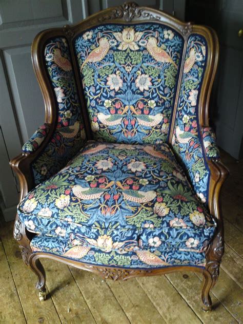 an ornately decorated chair sitting on top of a wooden floor next to a wall