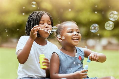 Premium Photo | Black kids children and blowing bubbles at park having ...