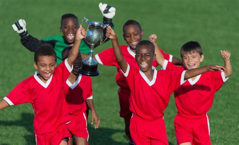 A kid's soccer team celebrating with a trophy. - INNERLINK