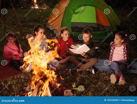 Children Reading Book with Flashlight Outdoors. Summer Camp Stock Image ...