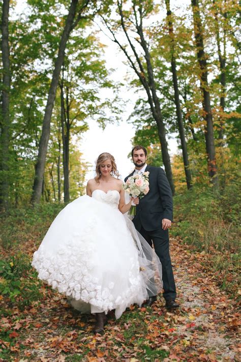 the bride and groom are walking through the woods in their wedding ...