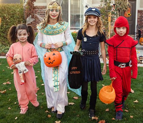 Group of kids dressed in Halloween costumes going trick or treating ...