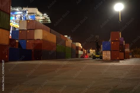 operation of container terminal at night. Unloading container ship at ...