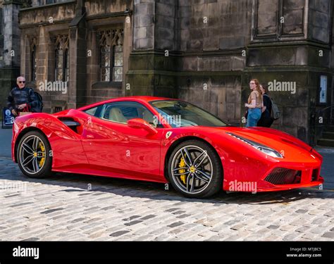 People look enviously at a bright red Ferrari 488 GTB coupe sports car ...