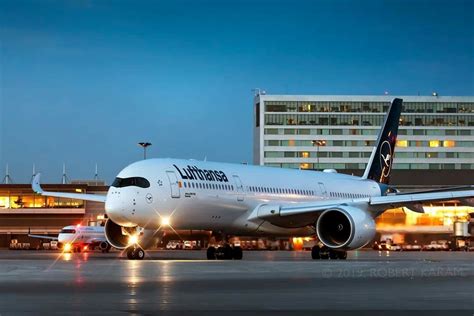 a large jetliner sitting on top of an airport tarmac at night with ...