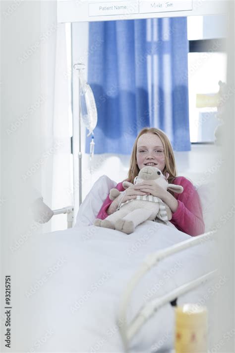 Portrait of smiling girl lying in hospital bed Stock Photo | Adobe Stock