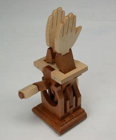 a wooden sculpture of a hand holding a piece of wood