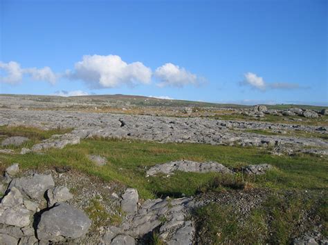 an open field with rocks and grass on the ground